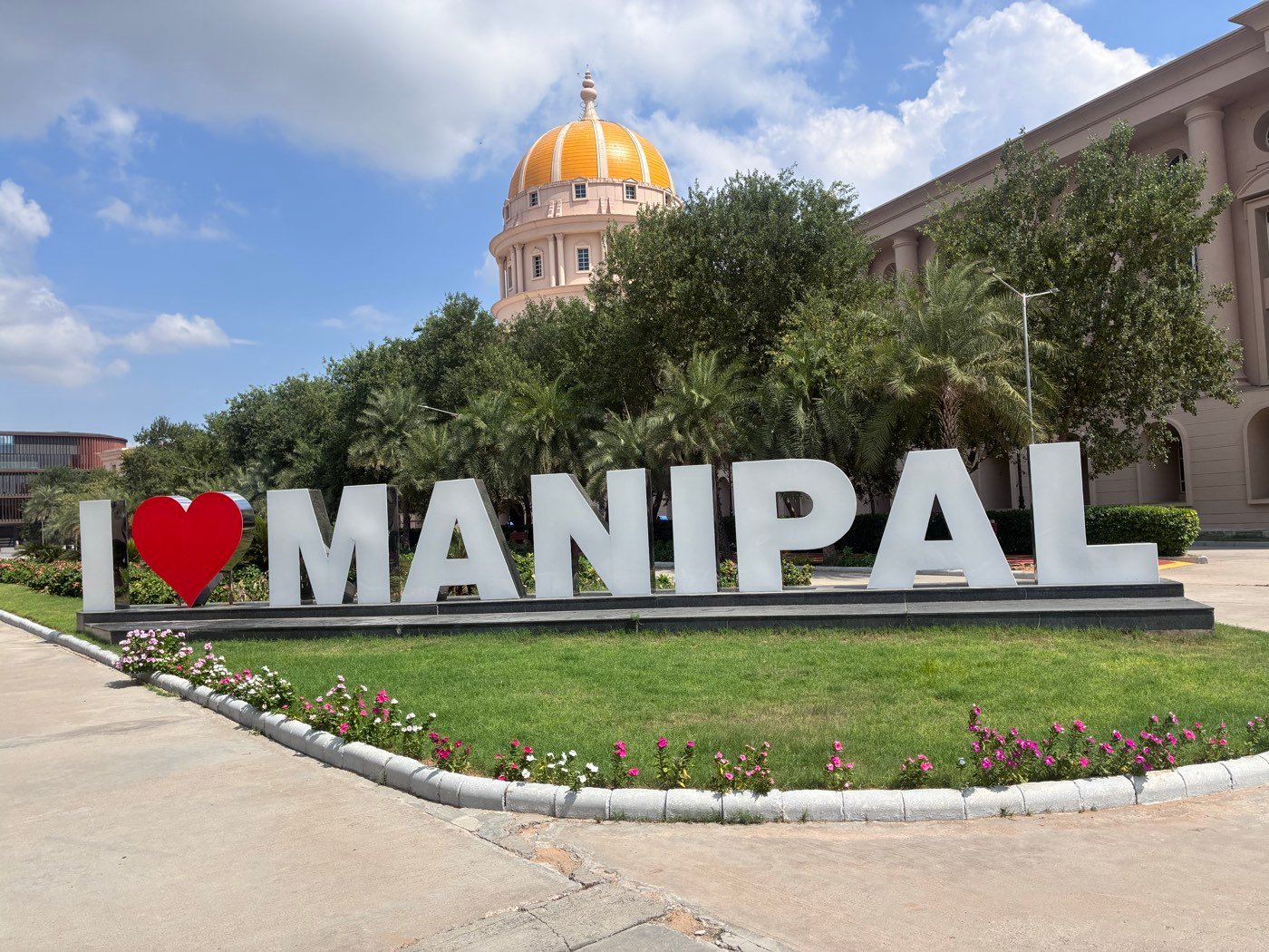 The I ♥ MANIPAL sign on the Manipal University Jaipur campus, with the university's golden dome behind it