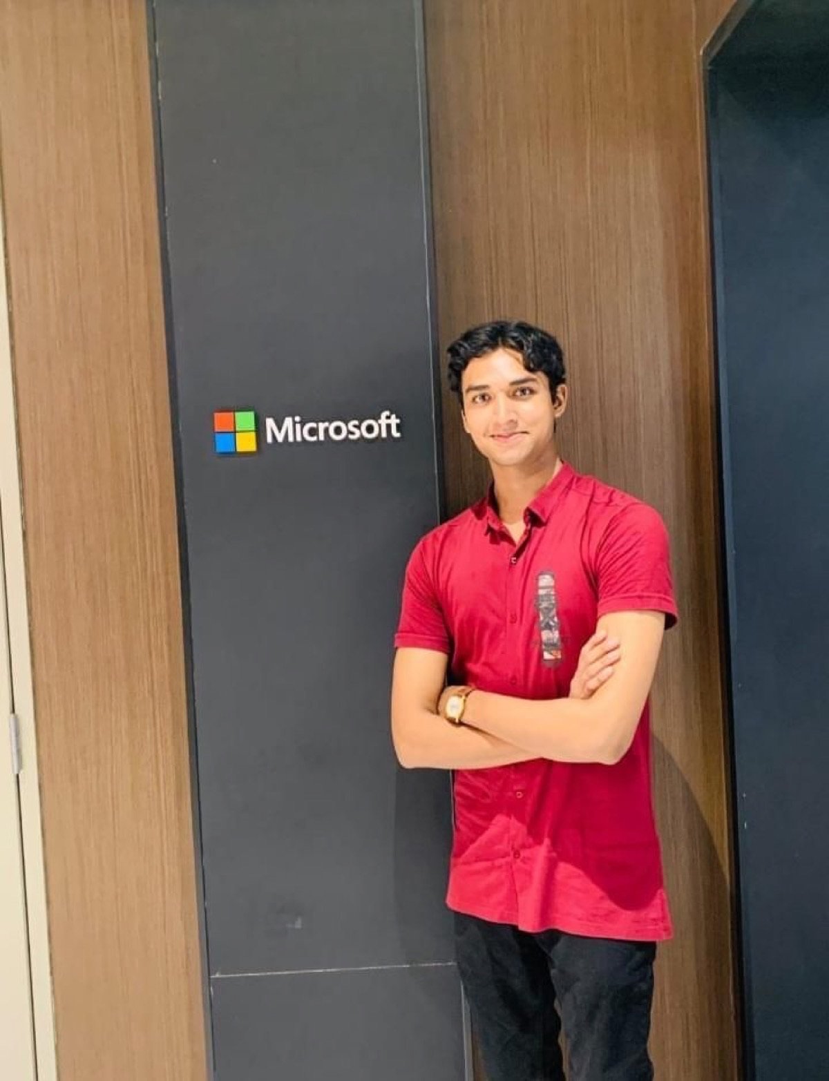 Chirag Jain standing beside the Microsoft sign at a Microsoft office