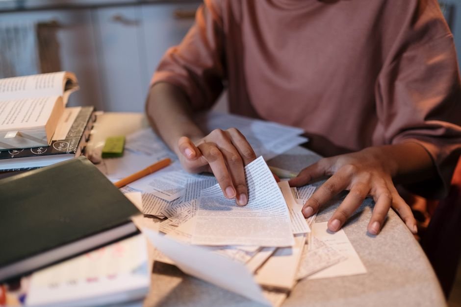 A student revising at a table with textbooks